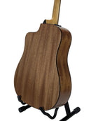 The back of a wooden acoustic guitar with a natural wood finish, displayed on a black stand against a light gray background.