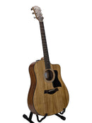 A cutaway acoustic-electric guitar with a natural wood body and dark neck, displayed on a black stand against a light gray background.