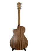 The back view of a wooden acoustic guitar on a stand, showcasing its rich grain pattern and cutaway body against a neutral gray background.