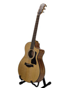 An acoustic-electric guitar with a natural wood finish and black pickguard, displayed on a black stand against a light gray background.