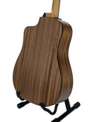 The back of an acoustic guitar with a rich brown wood grain finish, displayed on a black guitar stand against a clean white background.
