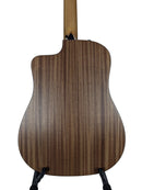 The back of a acoustic-electric guitar with a dark brown wood grain finish, displayed on a stand against a light gray background.