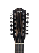 Close-up of a Taylor 12-string guitar headstock with dark wood grain, silver tuning pegs, and white Taylor branding on a light gray background.