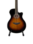 A cutaway acoustic-electric guitar with a sunburst finish, displayed on a white circular pedestal stand against a light gray background.