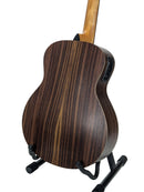The back of an acoustic guitar with a dark brown wood grain finish, displayed on a black stand against a white background.
