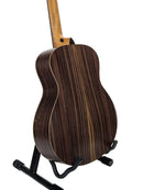 The back of an acoustic guitar with a dark brown wood grain finish, displayed on a black stand against a white studio background.