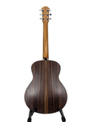 The back of an acoustic guitar with a dark brown wood grain finish, displayed on a stand against a white studio background.
