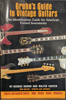 Book titled 'Gruhn's Guide to Vintage Guitars' on a pegboard background